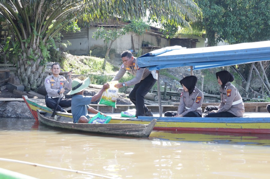 Polisi Gunakan Sampan Bagikan Sembako untuk Nelayan Sungai Siak